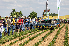 Teilnehmende an einer landwirtschaftlichen Maschinenvorführung.