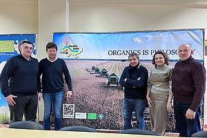 Five people in front of a poster.