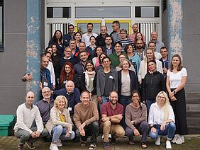 A group of about 40 people in front of a building.