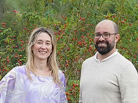 Ein Mann und eine Frau vor grüner Landschaft.