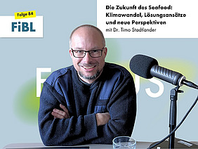 Ein Mann an einem Podcast-Mikrofon.