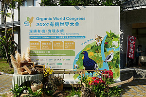 Eine Tafel vor einem Gebäude mit Informationen über den Organic World Congress.