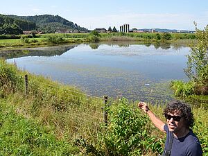 A man points to a pond.