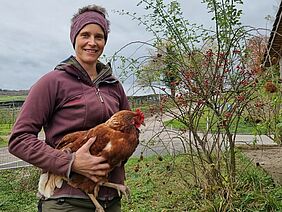 Frau mit Huhn auf dem Arm. 