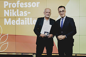 Zwei Männer mit Medaille.